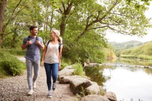 Man and Woman walking outside by stream